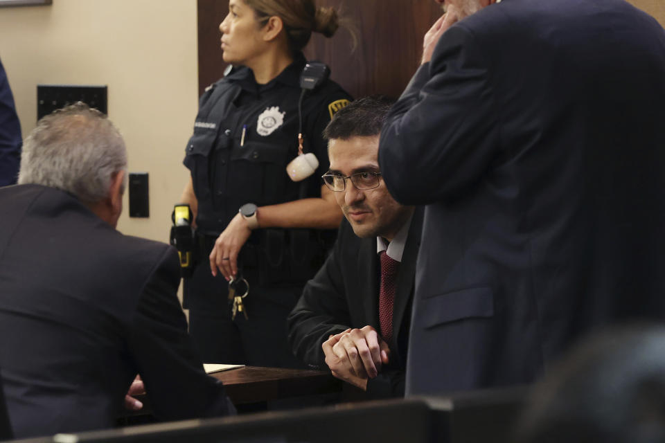 Capital murder defendant and former U.S. Border Patrol Juan David Ortiz talks with one of his attorneys, Joel Perez, before the start of the first day of the trial before Webb County State District Court Judge Oscar J. Hale, Monday, Nov. 28, 2022. Ortiz is charged in the 2018 deaths of four women near Laredo. The trial was moved to San Antonio because of pretrial media coverage in Laredo. (Jerry Lara/The San Antonio Express-News via AP)