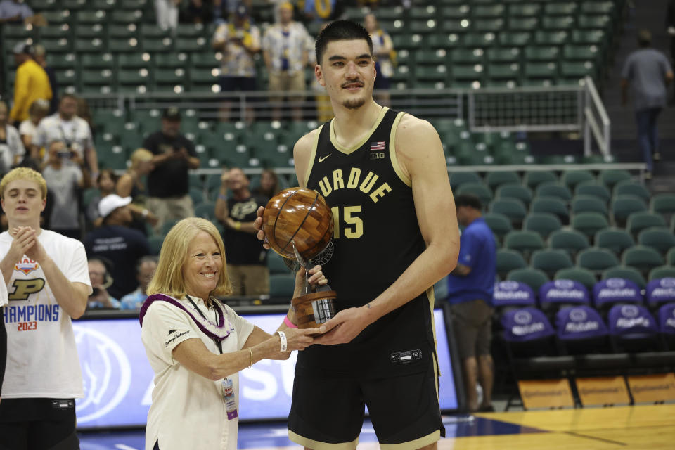 Purdue center Zach Edey (15) is awarded the MVP award by Lynn Babington, president of Chaminade University, after an NCAA college basketball game, Wednesday, Nov. 22, 2023, in Honolulu. Purdue defeated Marquette 78-75. (AP Photo/Marco Garcia)