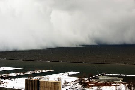 A lake-effect snow storm with freezing temperatures produces a wall of snow travelling over Lake Erie into Buffalo, New York. November 18, 2014. REUTERS/Gary Wiepert