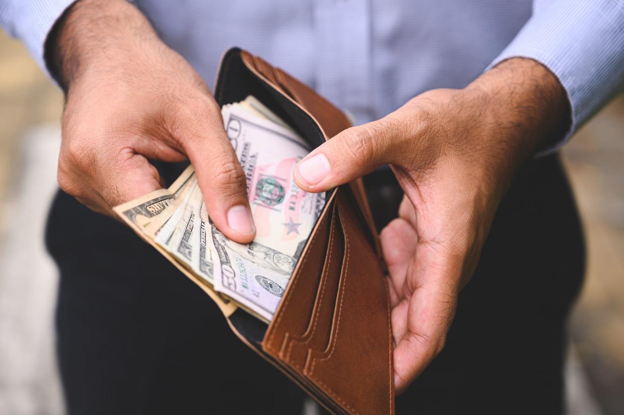 Close up Business man counting the money spread of cash in wallet.