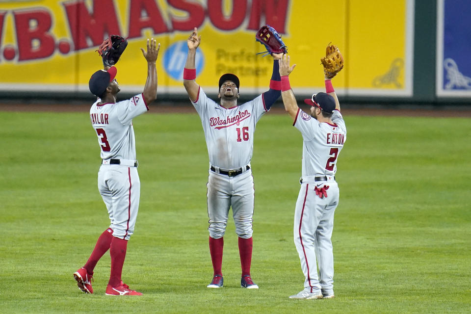 Washington Nationals outfielders, from left, Michael A. Taylor, Victor Robles and Adam Eaton celebrate after defeating the Baltimore Orioles during a baseball game, early Saturday, Aug. 15, 2020, in Baltimore. The Nationals won 15-3. (AP Photo/Julio Cortez)