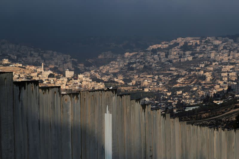 FILE PHOTO: A general view picture shows part of East Jerusalem neighbourhoods behind the Israeli barrier