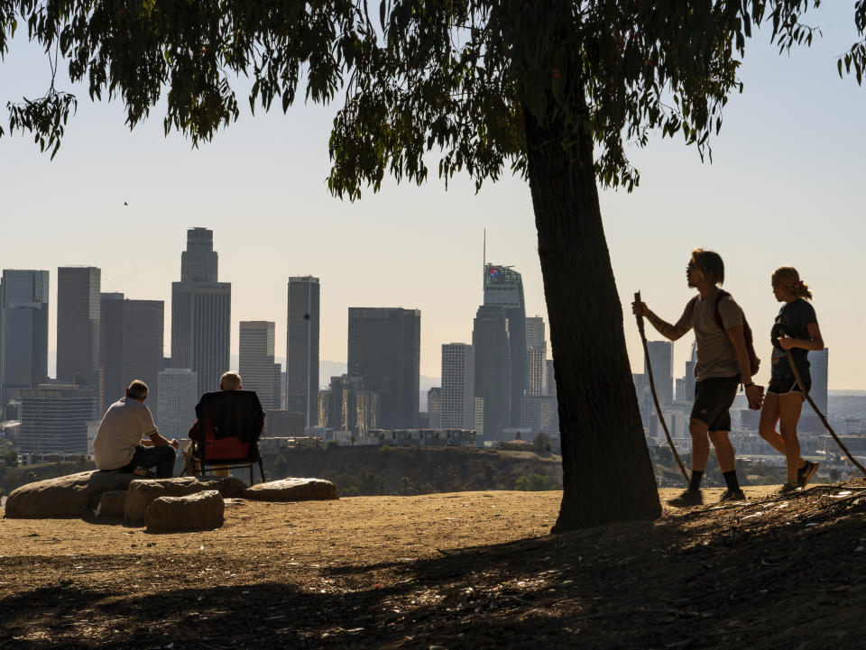 FILE - In this Monday, Jan. 11, 2021, file photo, people overlook the skyline of Los Angeles. California's population has declined for the first time in its history. State officials announced Friday, May 7 that the nation's most populous state lost 182,083 people in 2020. California's population is now just under 39.5 million. (AP Photo/Damian Dovarganes, File)