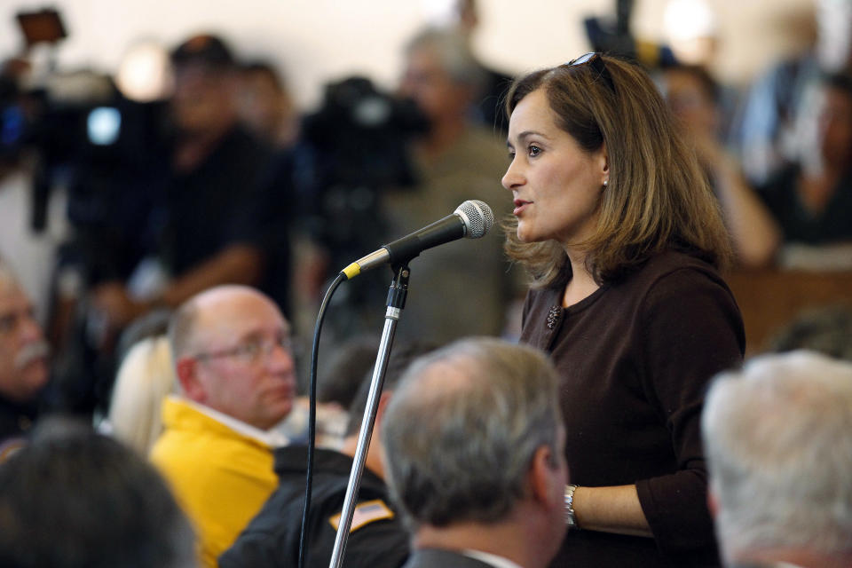 FILE - In this Sept. 11, 2010, file photo, Geisha Williams, right, then-senior vice president of energy delivery for Pacific Gas & Electric, speaks to hundreds of displaced San Bruno residents that jammed a town hall meeting at St. Roberts Catholic Church in San Bruno, Calif. PG&E said Sunday, Jan. 13, 2019, that CEO Williams was stepping down and that John Simon, the company's general counsel, would serve as interim CEO until a replacement is found. (AP photo/Tony Avelar, File)