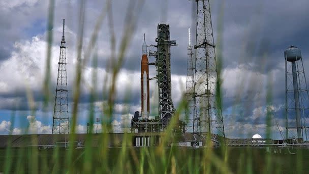 PHOTO: The Artemis 1 rocket is framed by tall grass as she stands ready on Launch Pad 39-B at the Kennedy Space Center, Aug. 26, 2022, in Cape Canaveral, Fla. (Brynn Anderson/AP)