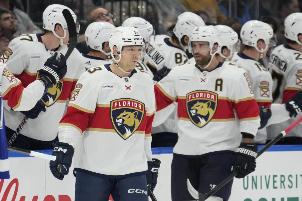 Florida Panthers center Sam Reinhart (13) celebrates with defenseman Aaron Ekblad (5) and the bench after scoring against the Tampa Bay Lightning during the second period of an NHL hockey game Wednesday, Dec. 27, 2023, in Tampa, Fla. (AP Photo/Chris O'Meara)