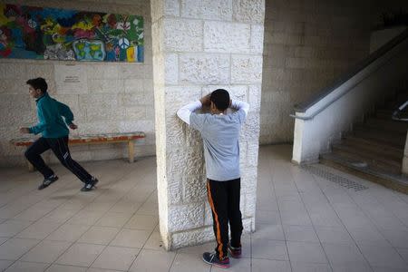 Children play hide-and-seek during lunch break at the Hand in Hand Arab Jewish bilingual school in Jerusalem December 3, 2014. REUTERS/Ronen Zvulun