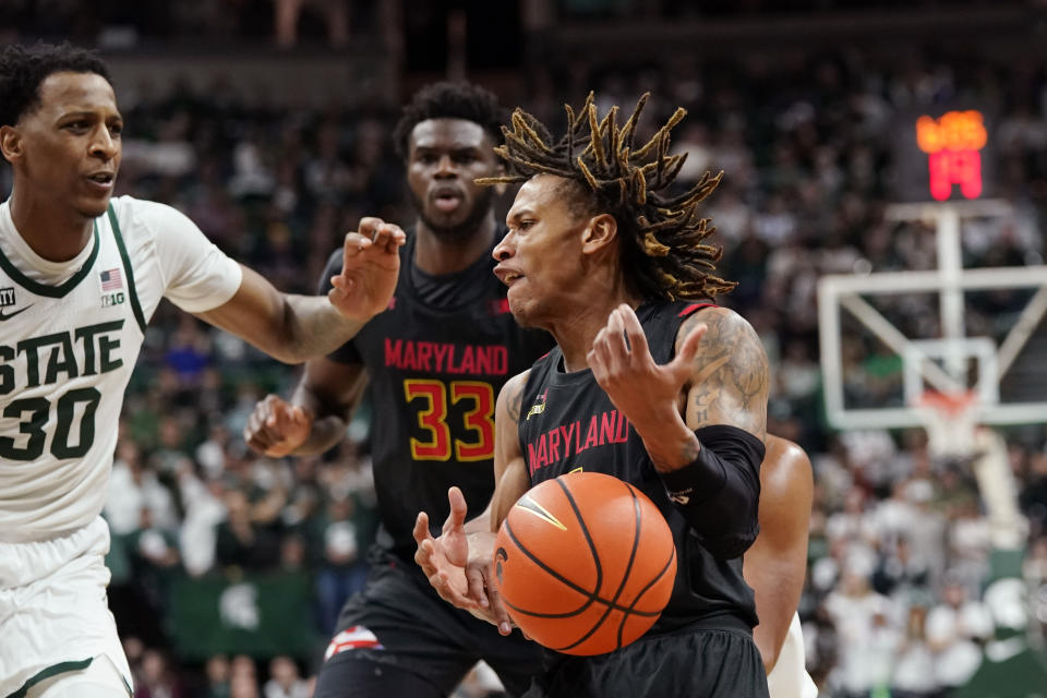 Maryland guard Fatts Russell loses control of the ball net to Michigan State forward Marcus Bingham Jr. (30) during the first half of an NCAA college basketball game, Sunday, March 6, 2022, in East Lansing, Mich. (AP Photo/Carlos Osorio)