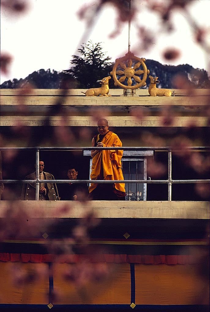 Circa 1970, the Dalai Lama, in the orange robes of a monk, steps out from his temple to bless the crowd of refugees at Dharamsala in the state of Himachal Pradesh.&nbsp;