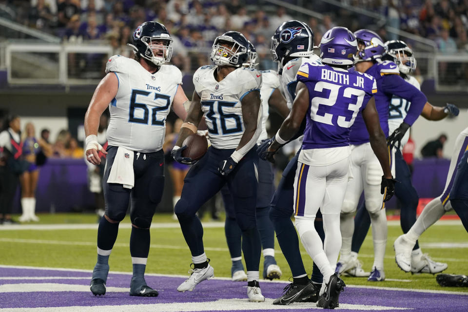 Tennessee Titans' Julius Chestnut (36) and Corey Levin (62) celebrate Chestnut's touchdown run as Minnesota Vikings cornerback Andrew Booth Jr. (23) looks on in the second half of a preseason NFL football game, Saturday, Aug. 19, 2023, in Minneapolis. (AP Photo/Charlie Neibergall)