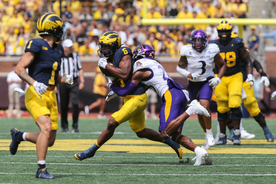 ANN ARBOR, MI - 2 WRZEŚNIA: Szeroki odbiorca Michigan Wolverines Cornelius Johnson (6) biegnie z piłką po złapaniu podania, próbując uniknąć ataku defensywnego obrońcy East Carolina Pirates Shavona Revela (28) w trzeciej kwarcie meczu futbolu akademickiego między East Carolina Pirates i Michigan Wolverines 2 września 2023 r. na stadionie Michigan w Ann Arbor w stanie Michigan. (Zdjęcie: Scott W. Grau/Icon Sportswire via Getty Images)