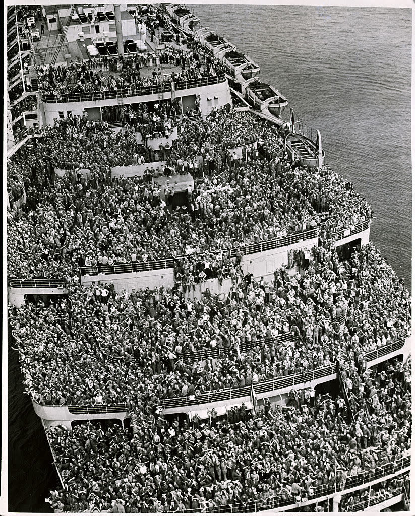 A historical photo of a ship's deck crowded with passengers