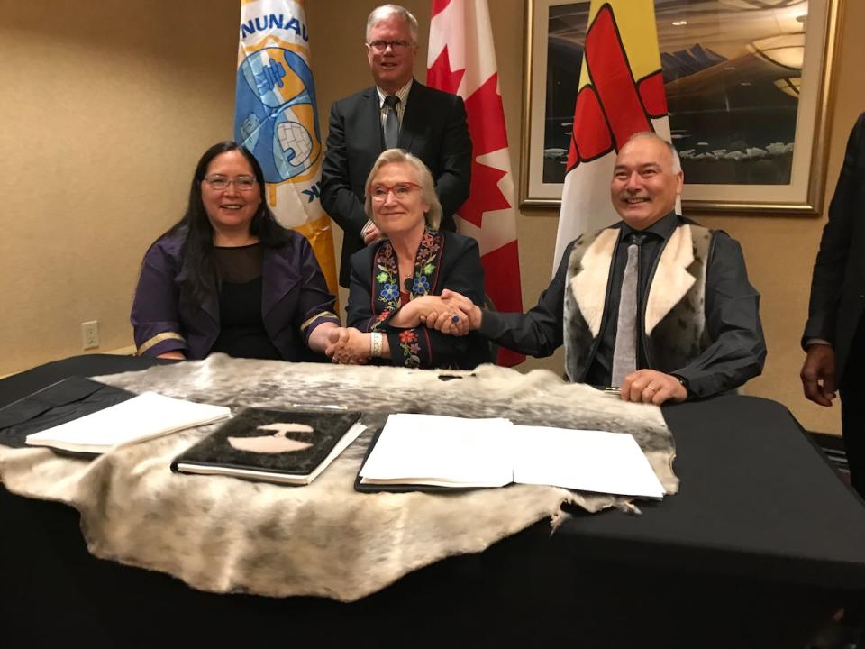 President of Nunavut Tunngavik Inc. Aluki Kotierk shakes hands with Canada's then-Minister of Crown-Indigenous Relations Carolyn Bennett and Nunavut's then-Premier Joe Savikataaq after they signed the devolution agreement-in-principle in 2019. 