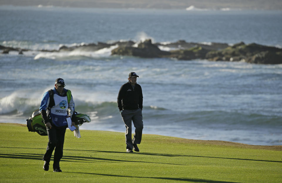 Phil Mickelson walks up the 18th fairway of the Pebble Beach Golf Links with his brother and caddie Tim Mickelson during the final round of the AT&T Pebble Beach Pro-Am golf tournament Monday, Feb. 11, 2019, in Pebble Beach, Calif. Mickelson won the tournament after finishing at 19-under-par. (AP Photo/Eric Risberg)