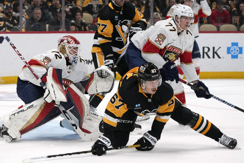 Florida Panthers' Niko Mikkola (77) clears Pittsburgh Penguins' Rickard Rakell (67) from in front of Panthers goaltender Sergei Bobrovsky (72) during the second period of an NHL hockey game in Pittsburgh, Friday, Jan. 26, 2024. (AP Photo/Gene J. Puskar)