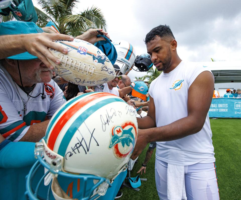 Miami Dolphins quarterback Tua Tagovailoa (1) signs autographs after NFL football training camp at Baptist Health Training Complex in Hard Rock Stadium on Sunday, Aug. 7, 2022 in Miami Gardens, Fla. (David Santiago/Miami Herald via AP)
