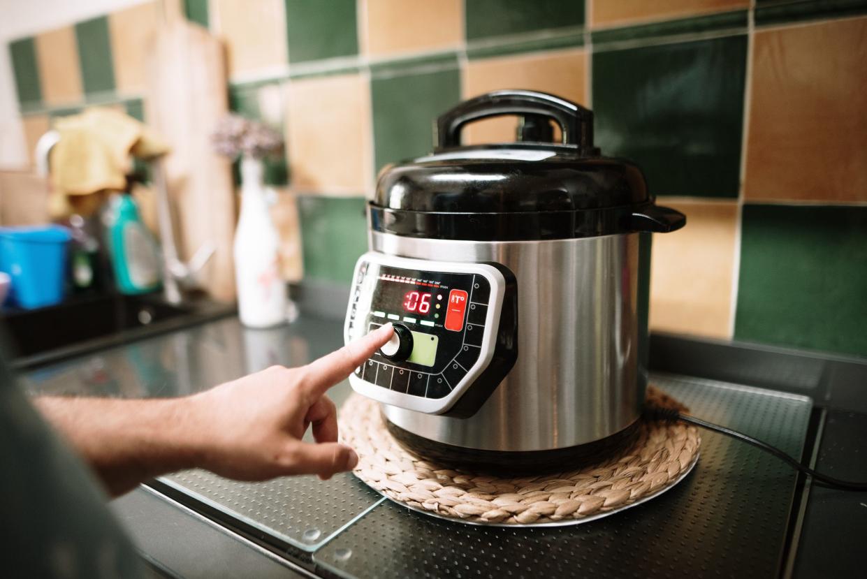 A hand programming an automatic pot