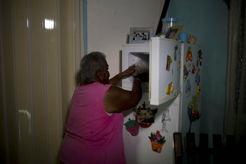 Pura Castell pone en su congelador las tres piezas de pollo que recibió de una tienda administrada por el gobierno como parte de su cuota mensual de alimentos distribuidos por el Estado en Bauta, Cuba, el viernes 12 de abril de 2019. (AP Foto / Ramón Espinosa)