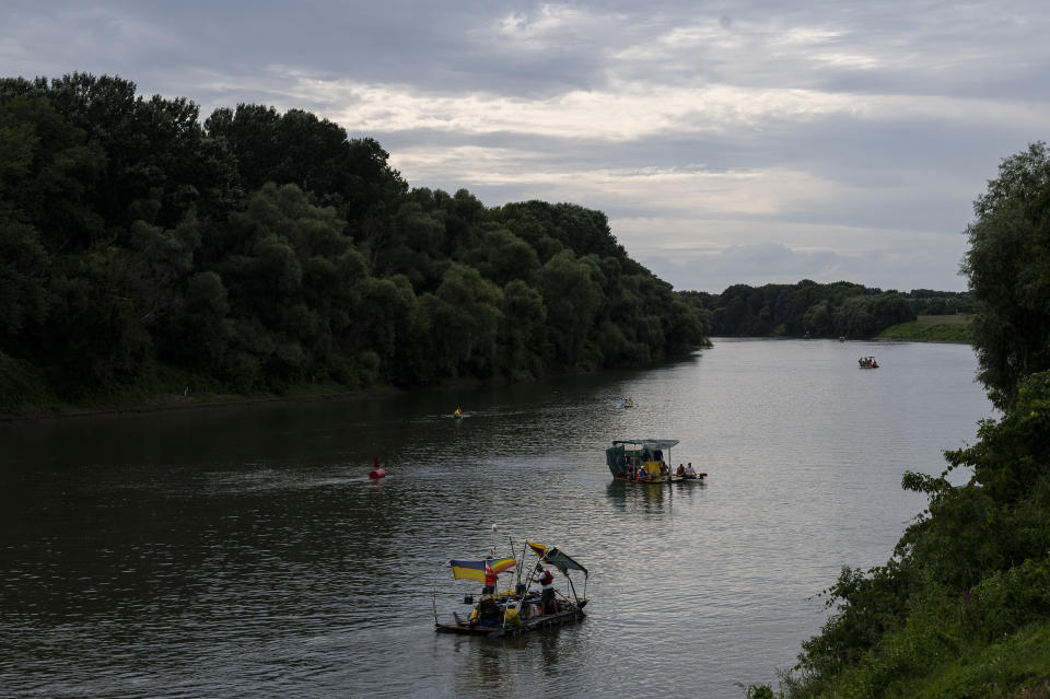 Volunteers paddle their boats on the Tisza River as they participate in Plastic Cup event, where they scour Hungary's second-largest river for trash on Tuesday, Aug. 1, 2023. Life-jacketed rivergoers of all ages pile into dozens of canoes to scour Hungary’s second-largest river for trash that has flowed downstream. (AP Photo/Denes Erdos)