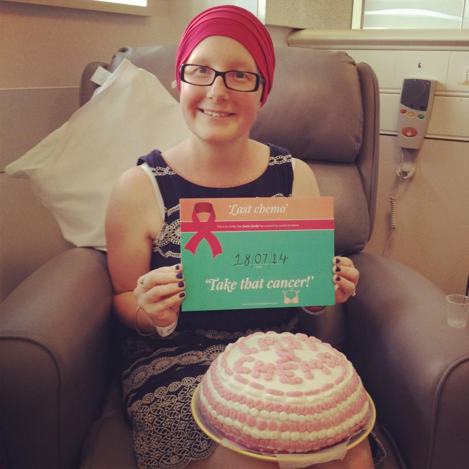 Jackie Scully holding up a sign with her last treatment date for chemotherapy 