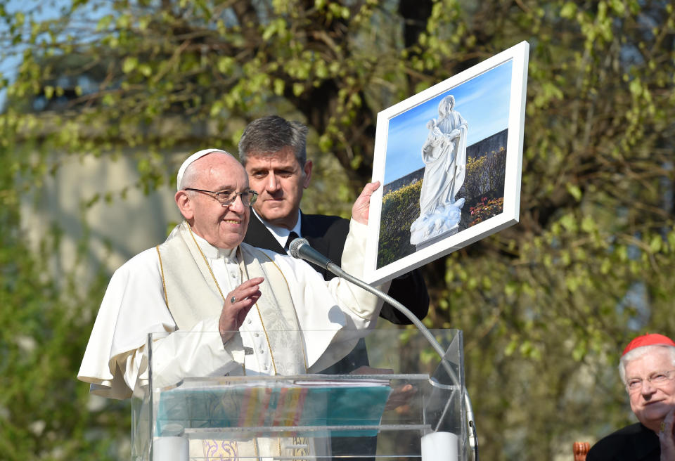 Pope Francis holds up a framed image of the Madonna during his visit at Milan's Forlanini neighborhood known as Case Bianche (white houses), as part of his one-day pastoral visit to Monza and Milan, Italy’s second-largest city, Saturday, March 25, 2017. The pope's first stop Saturday is a housing project on the outskirts of Italy's fashion and finance capital, a stop that underlines the pope's view that the peripheries offer a better view of reality than well-tended and prosperous city centers. (L'Osservatore Romano/Pool Photo via AP)