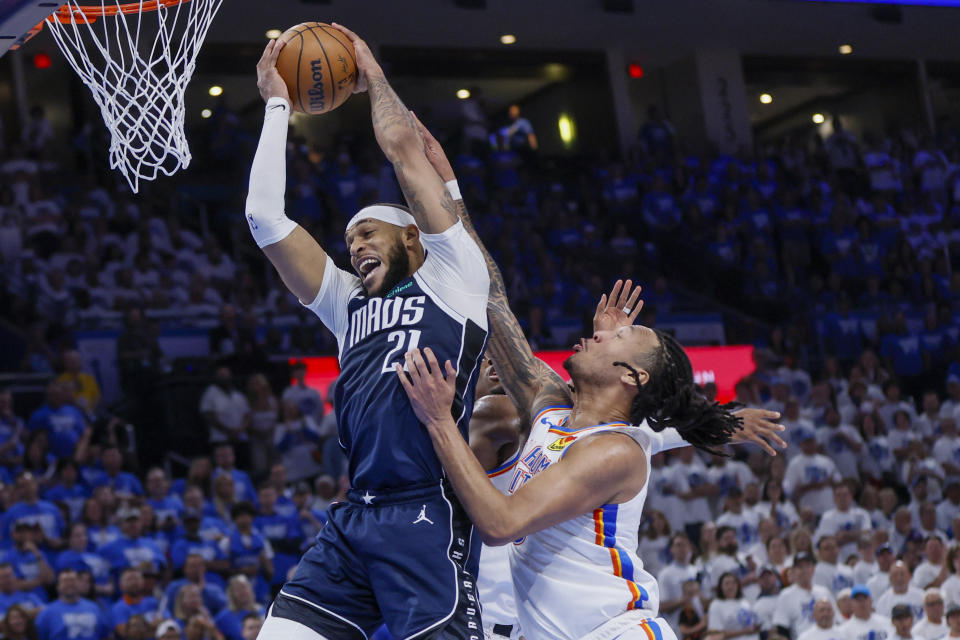Dallas Mavericks center Daniel Gafford (21) collects a rebound in front of Oklahoma City Thunder forward Jaylin Williams, right, and guard Shai Gilgeous-Alexander, back, during the first half of Game 1 of an NBA basketball second-round playoff series, Tuesday, May 7, 2024, in Oklahoma City. (AP Photo/Nate Billings)
