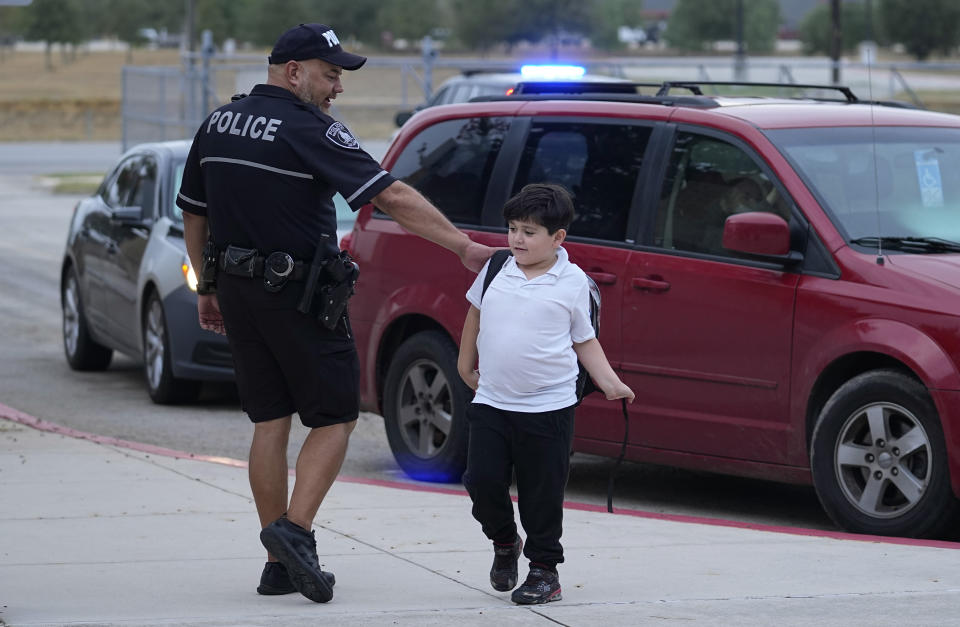 Southside Independent School District police officer Ruben Cardenas, left, greets a student arriving at Freedom Elementary School, Wednesday, Aug. 23, 2023, in San Antonio. Most Texas school districts say they are unable to comply with a new law requiring armed officers on every campus. The mandate was one of Republican lawmakers' biggest acts following the Uvalde school shooting in 2022 that killed 19 children and two teachers. (AP Photo/Eric Gay)