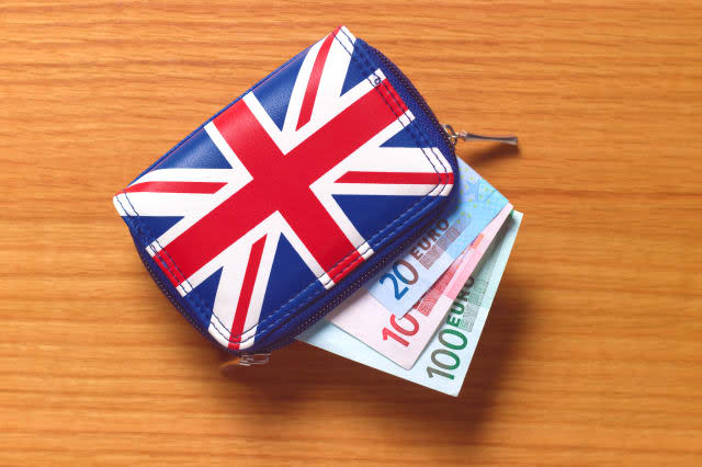 Union Jack purse on wooden background with Euros