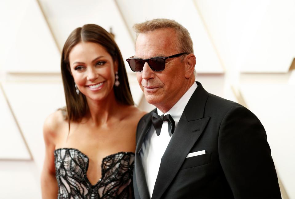 Christine Baumgartner and Kevin Costner pose at the Academy Awards in 2022