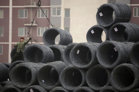 A labourer works on coils of steel wire at a steel wholesale market in Beijing January 17, 2012. REUTERS/Soo Hoo Zheyang/File Photo