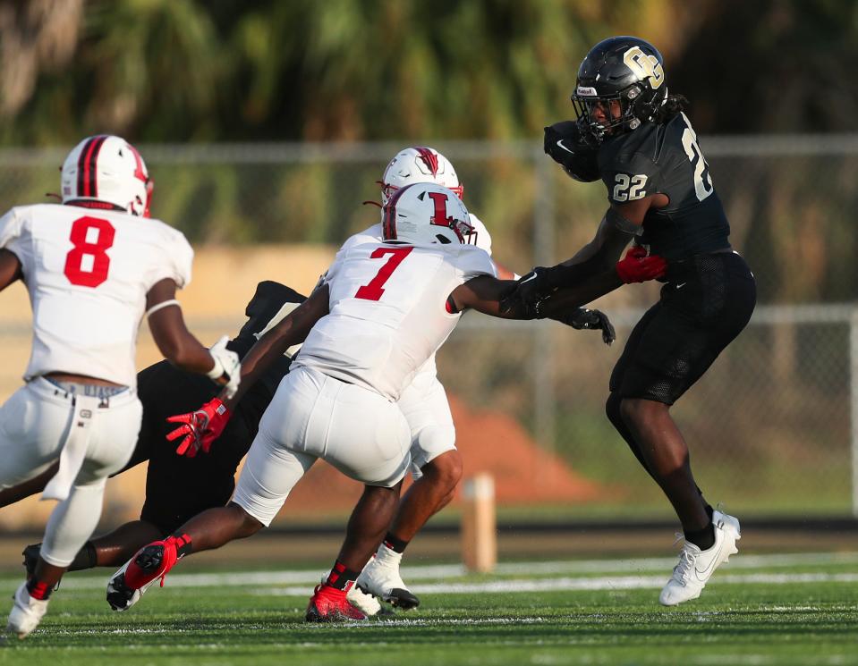 Golden Gate Titans running back Trayvon Jean (22) cuts back while running upfield during the first quarter of a game against the Immokalee Indians at Golden Gate High School in Naples on Friday, Sept. 1, 2023.