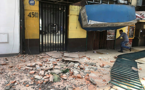 A man enters a damaged building after an earthquake in Mexico City - Credit: Eduardo Verdugo/AP