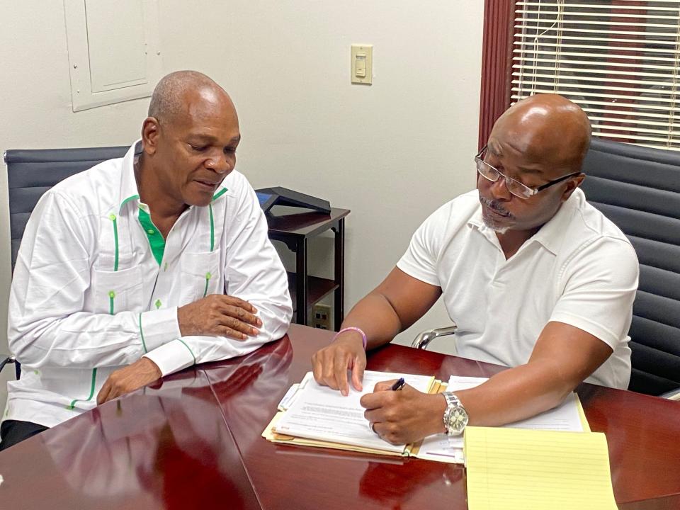 Haitian-American shipper Remy Lindor (left) with his attorney, John Howe, at Howe's West Palm Beach law offices.