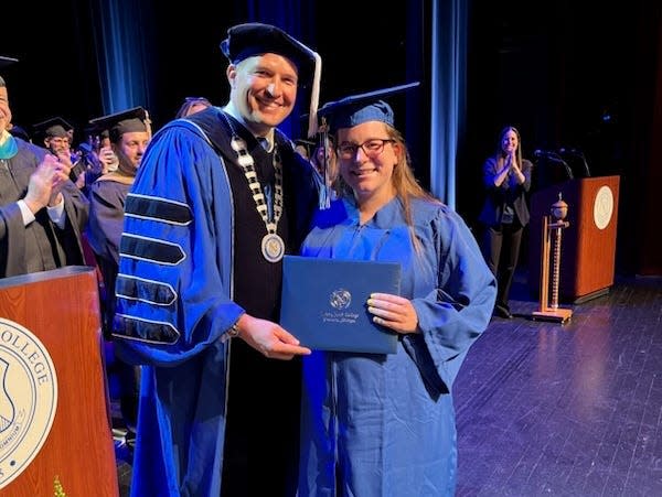 Russell Kavalhuna, president of Henry Ford College, poses with Kelsey Hudie. She was in labor when she accepted her diploma from him.