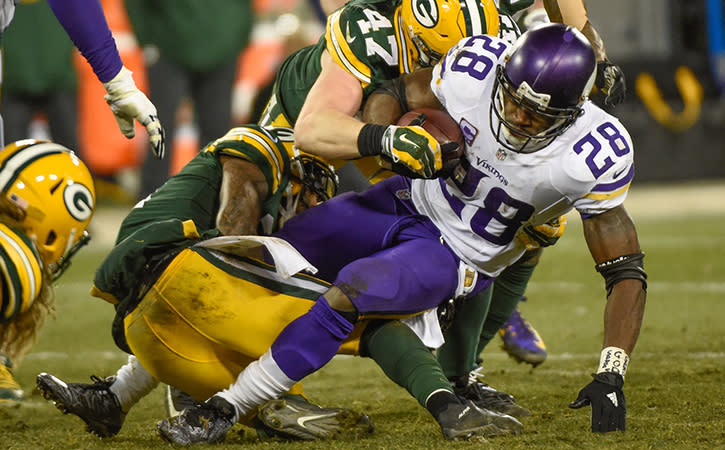 Minnesota Vikings' running back, Adrian Peterson, attempts to elude defenders.