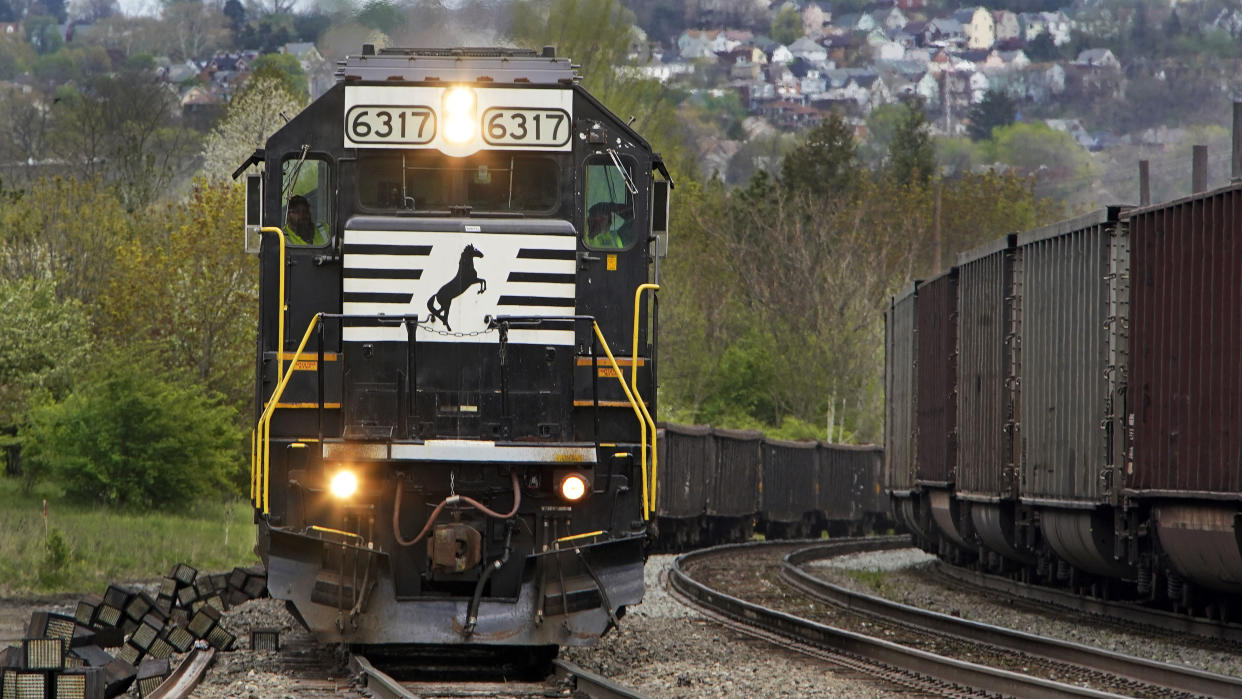 A Norfolk Southern freight train, left, waits on a siding, as another train passes in Homestead, Pa, Wednesday, April 27, 2022. (AP Photo/Gene J. Puskar)