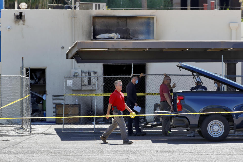 Fire investigators stand outside the Arizona Democratic Party headquarters Friday, July 24, 2020, in Phoenix. Fire investigators are looking into the cause of an early morning blaze that destroyed part of the Arizona and Maricopa County Democratic Party headquarters Friday. (AP Photo/Matt York)