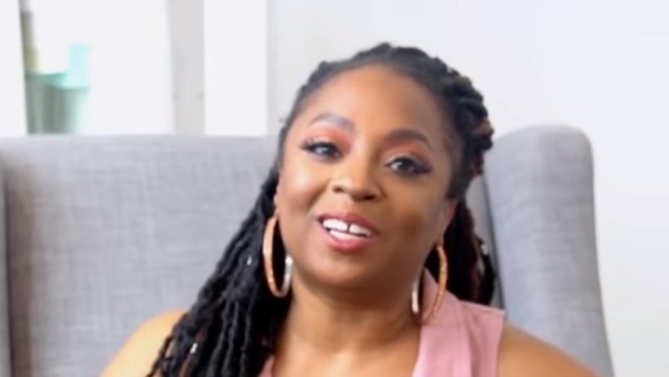 a photo of Dr. Lakara Foster, a Black woman wearing long braids