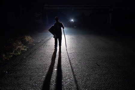 A migrant, traveling with a caravan of thousands from Central America en route to the United States, walks to Arriaga from Pijijiapan, Mexico October 26, 2018. REUTERS/Adrees Latif