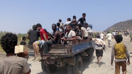 People ride a truck as they loot army depots in Yemen's southern port city of Aden March 27, 2015. REUTERS/Anees Manousr