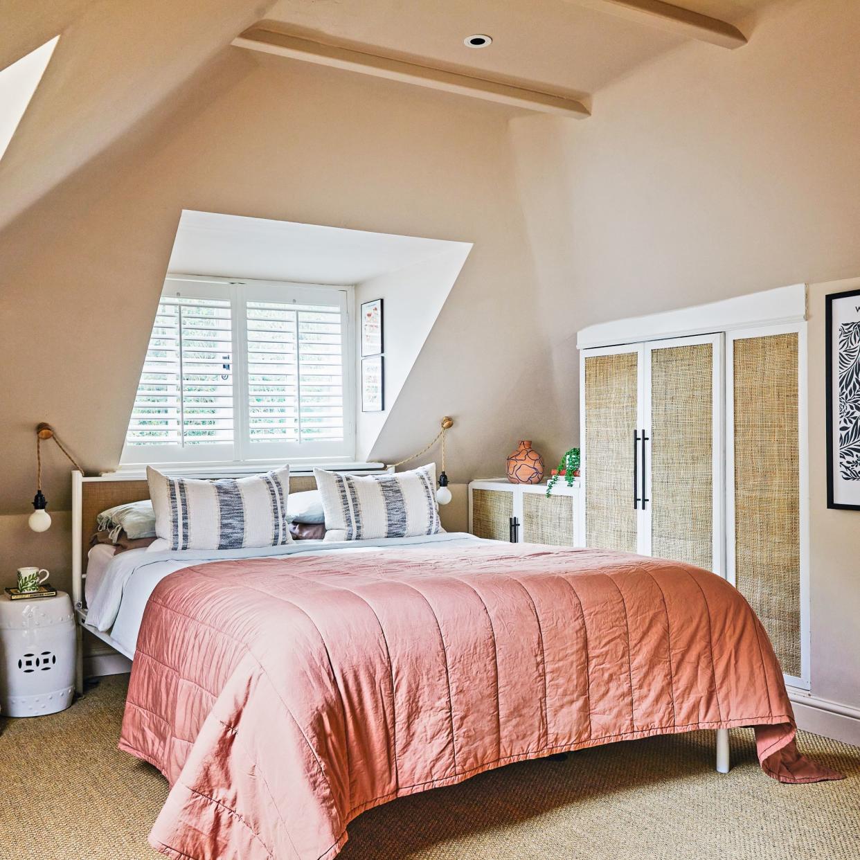  Bedroom with sloping eaves with king sized bed with pink bedding. 