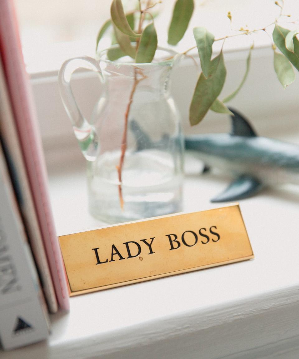 A gold office name tag with the 'lady boss' phrase.