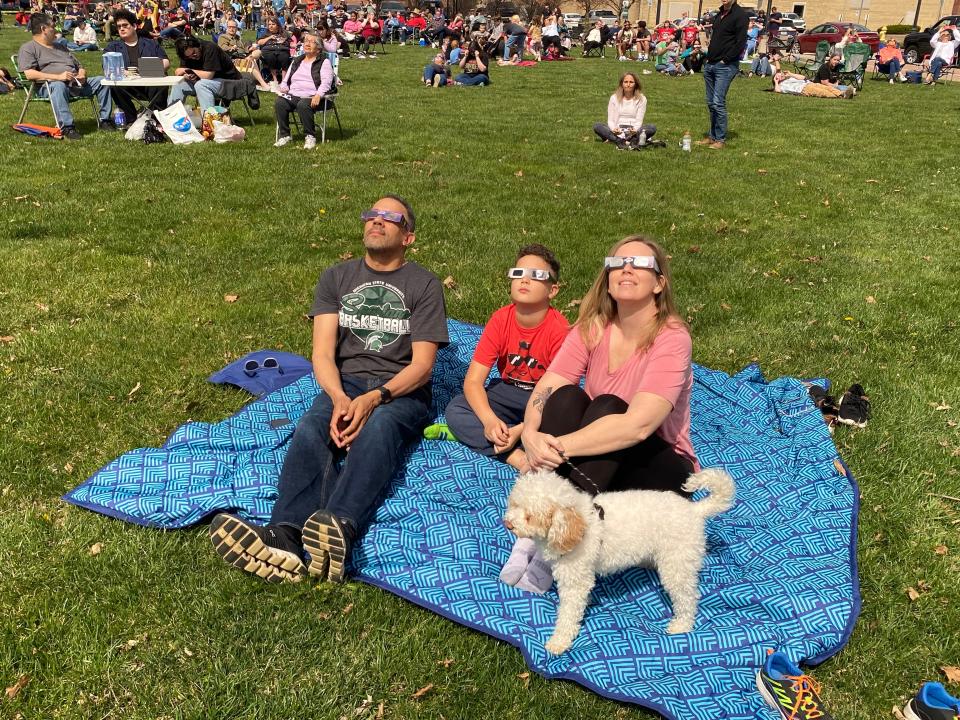 A family from Kalamazoo, Michigan — Chance McDermott, Erica Smith and their son, Naaman, and the family's dog, Lupo — made the three-hour drive Monday morning from their home to see the eclipse from Canan Commons in downtown Muncie.