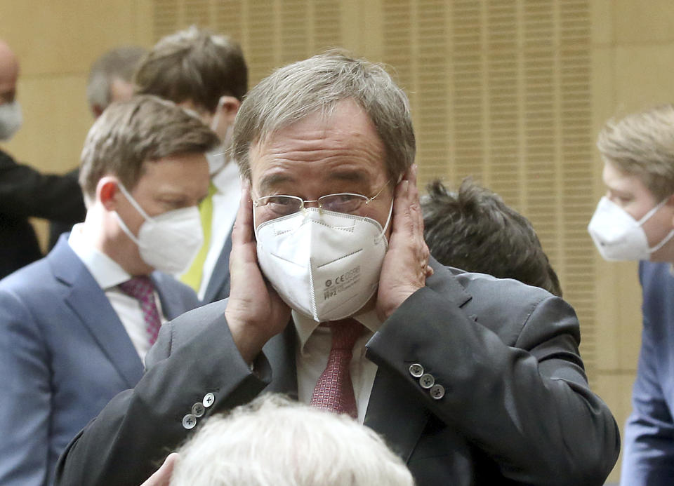 Armin Laschet, State Governor of North Rhine-Westphalia and candidate for chancellor of the CDU/CSU, follows the speeches in the Bundesrat wearing a mask to protect his mouth and nose in Berlin, Germany, Thursday, April 22, 2021. A plan by German Chancellor Angela Merkel’s government to mandate uniform restrictions in areas where the coronavirus is spreading too quickly has cleared its final legislative hurdle. (Wolfgang Kumm/dpa via AP)