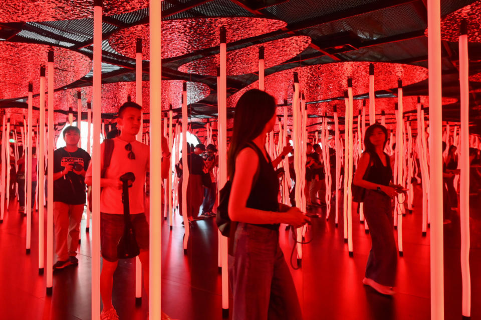 Fans of US singer Taylor Swift, also known as Swifties, walk through an installation in the 