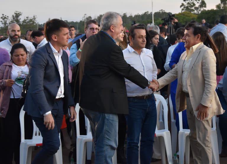 El caudillo provincial Rovira saluda al candidato oficialista Hugo Passalacqua, ante la mirada del gobernador Oscar Herrera Ahuad