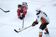 Chicago Blackhawks' Ian Mitchell (51) dives for a loose puck as Anaheim Ducks' Jakob Silfverberg skates nearby during the third period of an NHL hockey game Tuesday, Feb. 7, 2023, in Chicago. The Ducks won in overtime 3-2. (AP Photo/Charles Rex Arbogast)