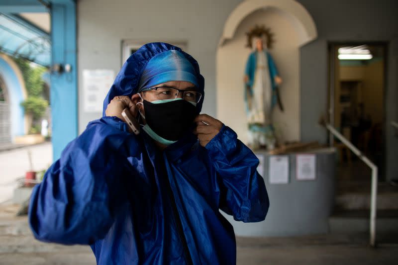 The Wider Image: Hazmat suits and holy water: two priests bring faith to Philippines lockdown