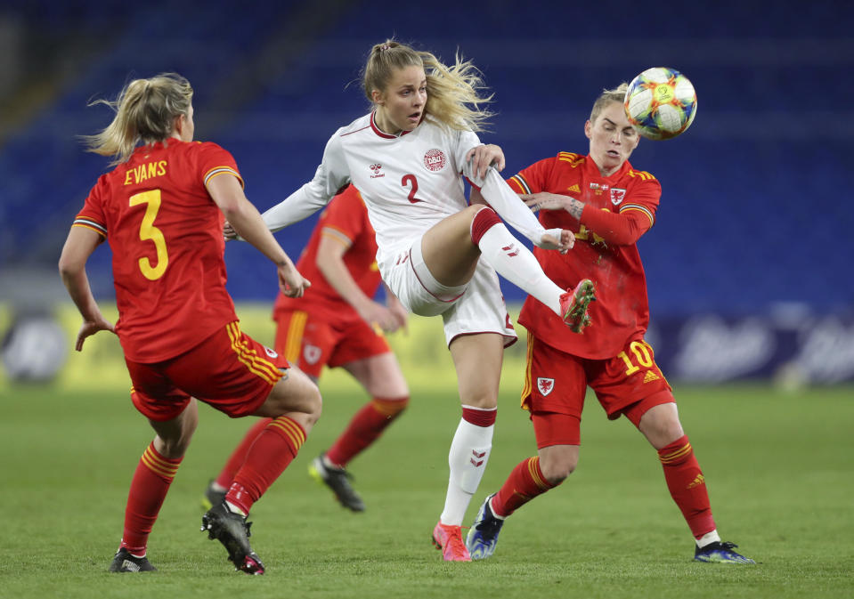<p>Denmark's Olivia Holt, centre, and Wales' Jess Fishlock, right, during their women's international friendly soccer match at Cardiff City Stadium, Cardiff, Wales, Tuesday April 13, 2021. (David Davies/PA via AP)</p>
