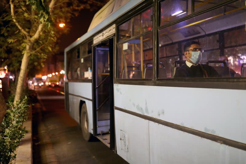 An Iranian man wears a protective mask as he sits in a bus, amid the outbreak of the coronavirus disease (COVID-19), in Tehran